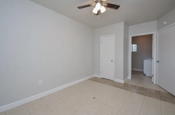 an empty room with chandelier fan