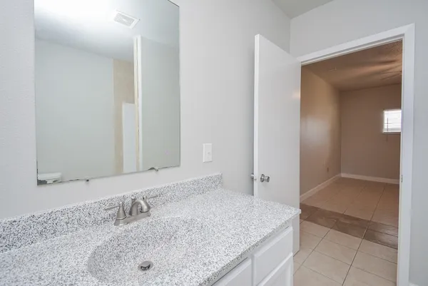 a bathroom with a granite countertop sink and mirror
