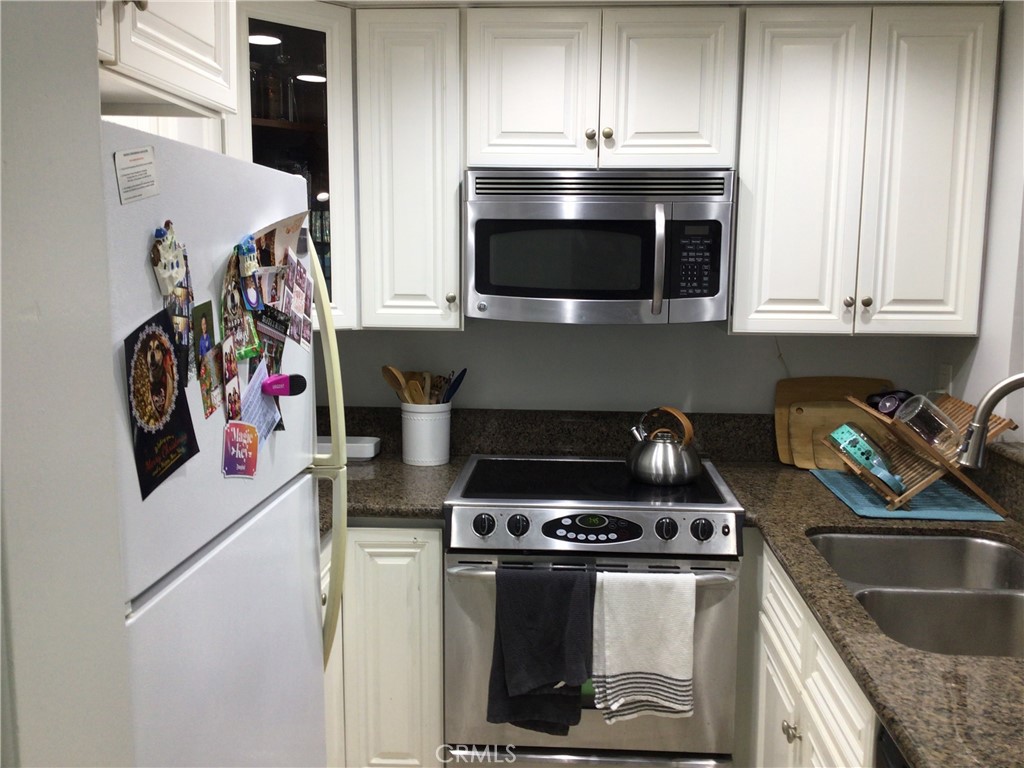 26161-815 Del Rey, Unit C Mission Viejo, CA 92691 - Photo 4 of 11 a kitchen with stainless steel appliances granite countertop a stove and a microwave