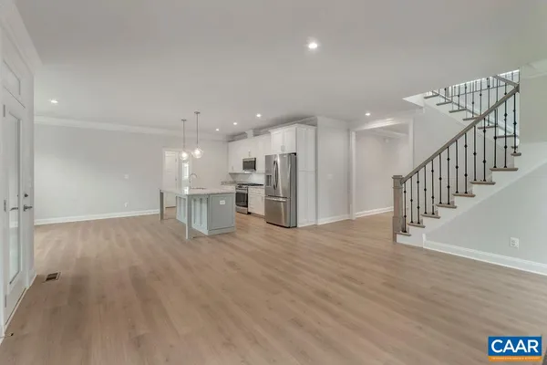 a kitchen with stainless steel appliances granite countertop a refrigerator a stove a sink dishwasher and a refrigerator with wooden floor