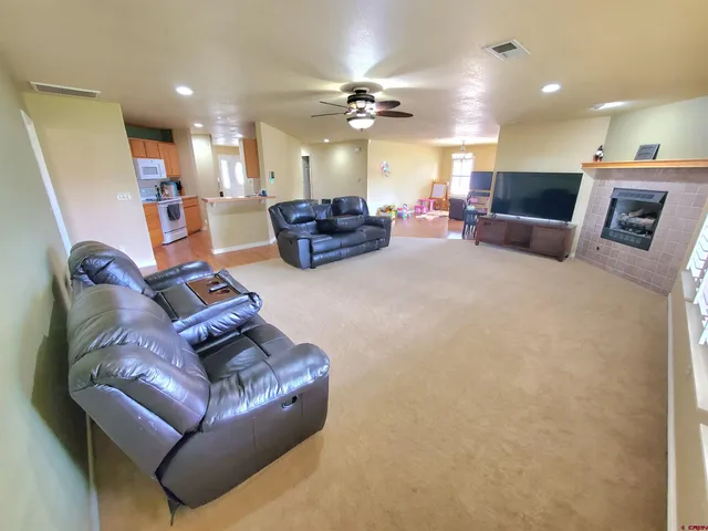 a living room with furniture kitchen view and a chandelier
