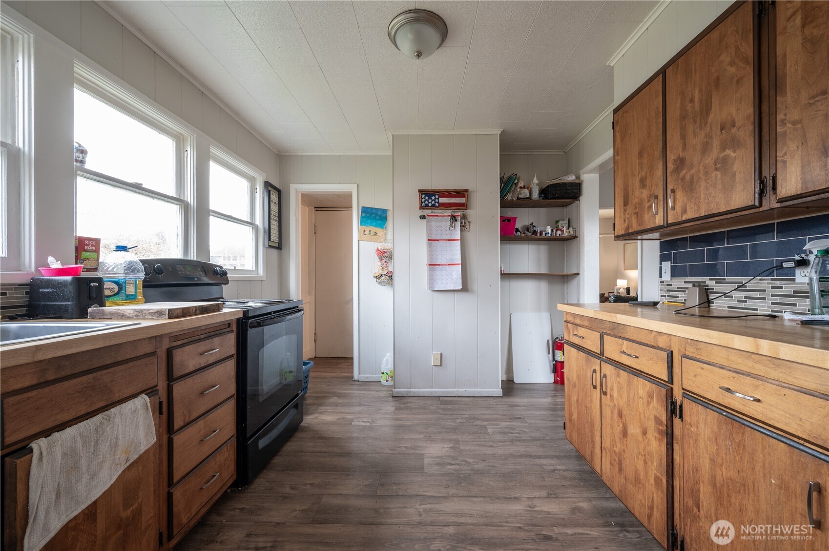 300 West 3rd Street Aberdeen, WA 98520 - Photo 6 of 28 a kitchen with stainless steel appliances granite countertop a refrigerator a sink dishwasher a stove and white countertops with wooden floor