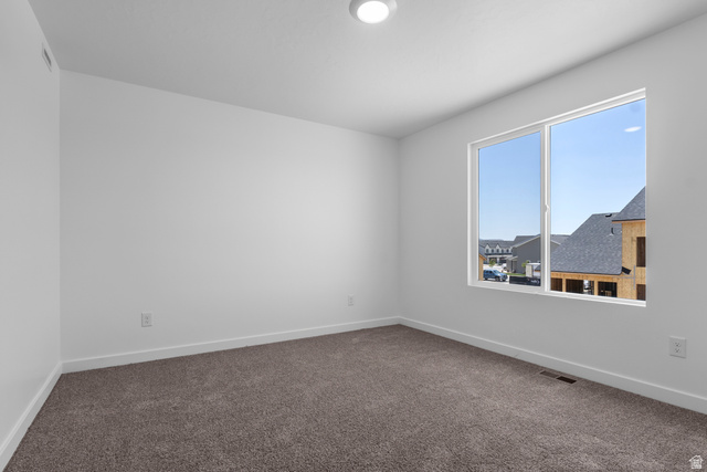 1355 West 2350 South, Unit 11 Perry, UT 84302 - Photo 26 of 39 Bright room with a large window, neutral carpeting, and white baseboards