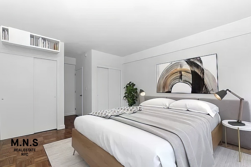 65 West 55th Street, Unit 10P Manhattan, NY 10019 - Photo 5 of 16 a bedroom with a bed and a window