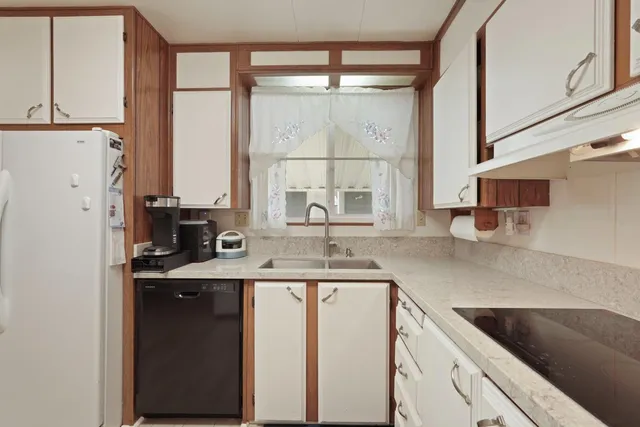 a kitchen with a sink cabinets and window