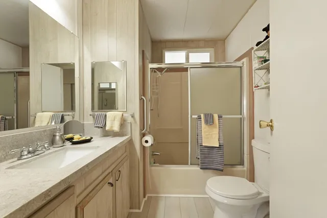 a bathroom with a granite countertop sink toilet and shower