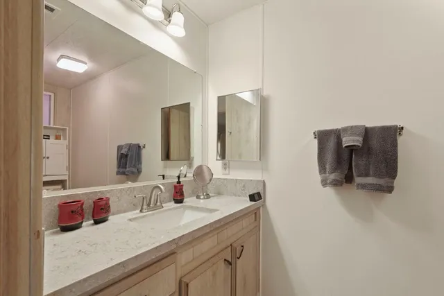 a bathroom with a granite countertop sink and a mirror