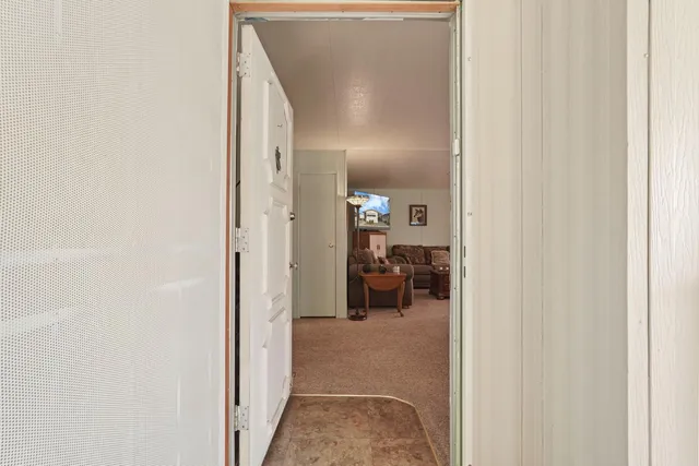 a view of a hallway with livingroom and a bathroom