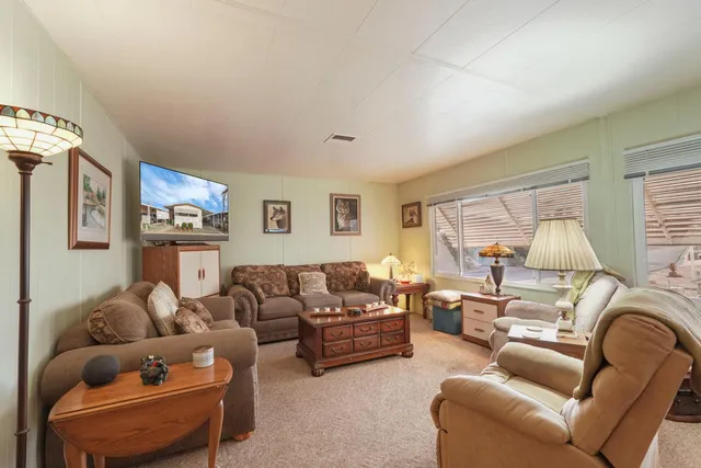 a living room with furniture a couch and a large window