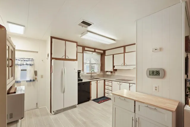 a kitchen with a refrigerator a sink and cabinets