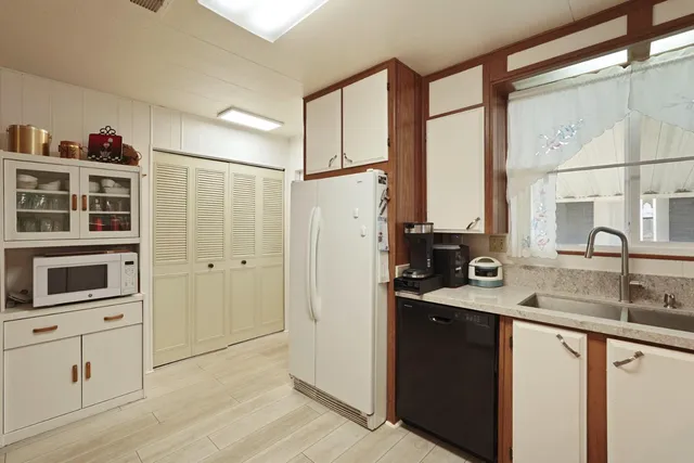 a kitchen with stainless steel appliances granite countertop a refrigerator and a sink