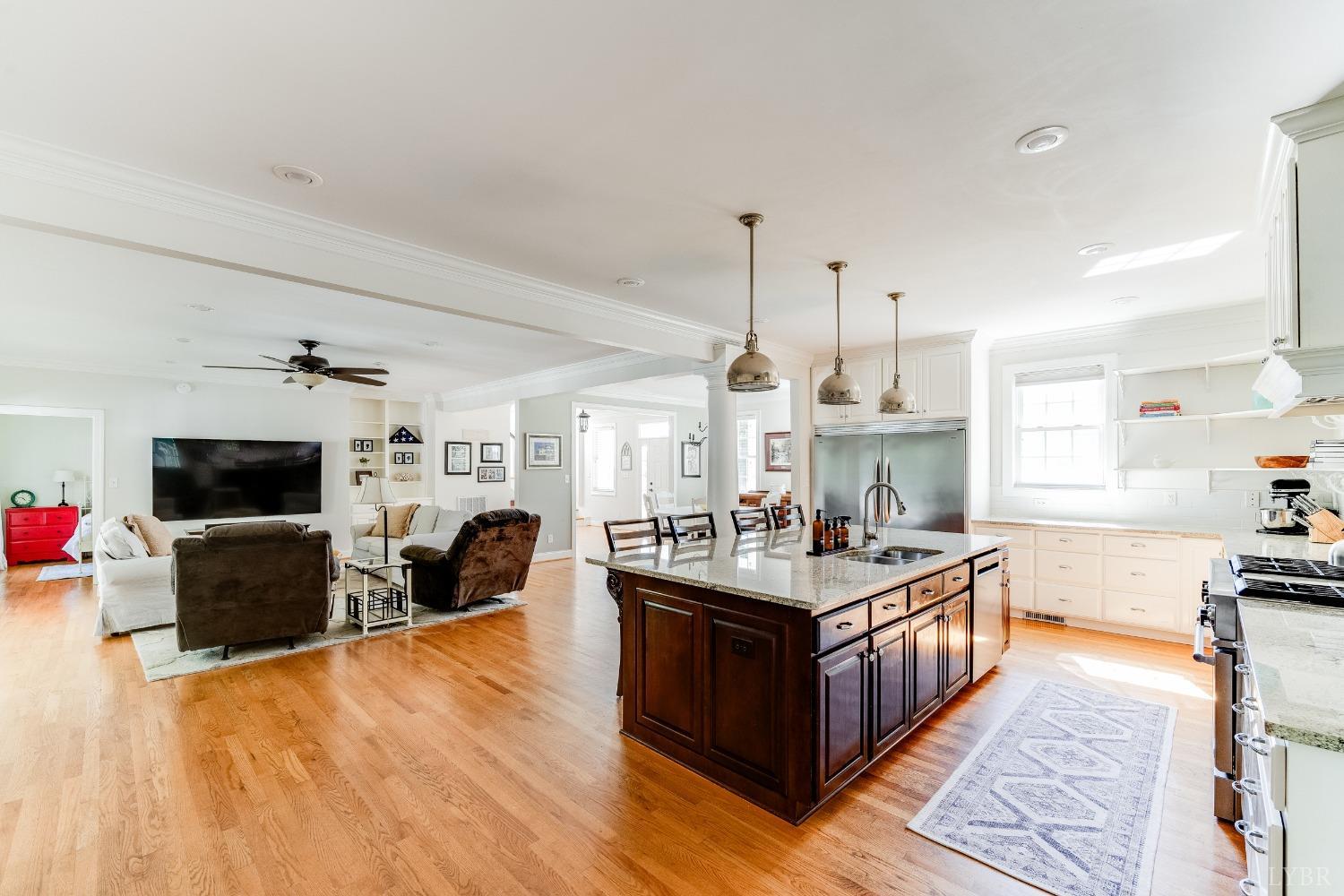 212 Barringer Drive Rustburg, VA 24588 - Photo 15 of 63 a large kitchen with stainless steel appliances a stove a sink dishwasher and a fireplace with wooden floor