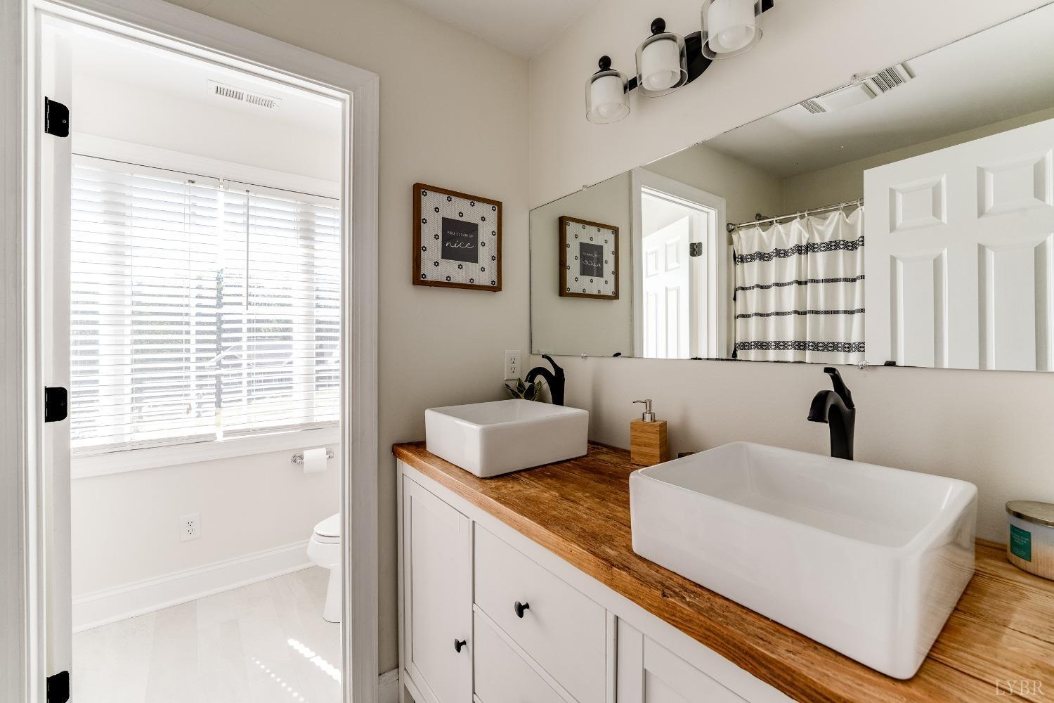 212 Barringer Drive Rustburg, VA 24588 - Photo 36 of 63 a bathroom with a granite countertop sink mirror and a bathtub