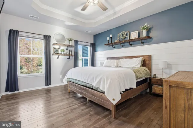 a large bed sitting in a bedroom next to a window and a chandelier