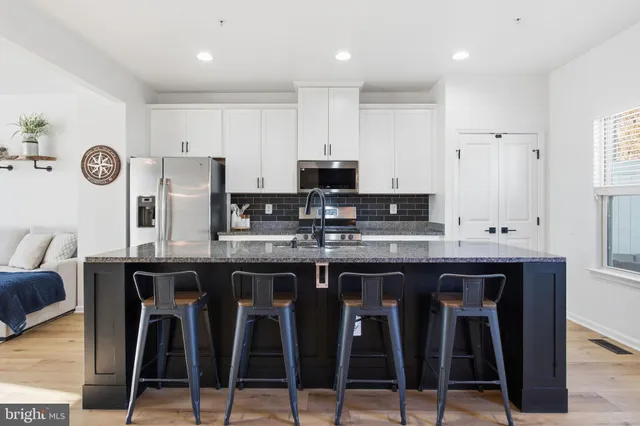 a kitchen with granite countertop a table chairs stove top oven and cabinets