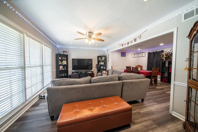 a living room with furniture a flat screen tv and a large window