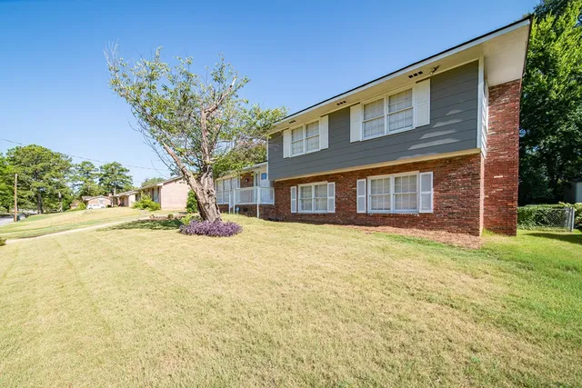 a yellow house with trees in front of it
