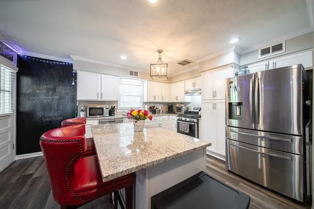 a kitchen with a refrigerator sink and cabinets