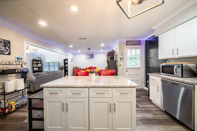 a kitchen that has a lot of cabinets a sink and appliances in it