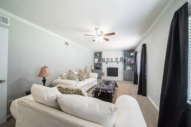 a living room with furniture and a ceiling fan