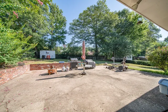 a view of a swimming pool with chairs and fire pit