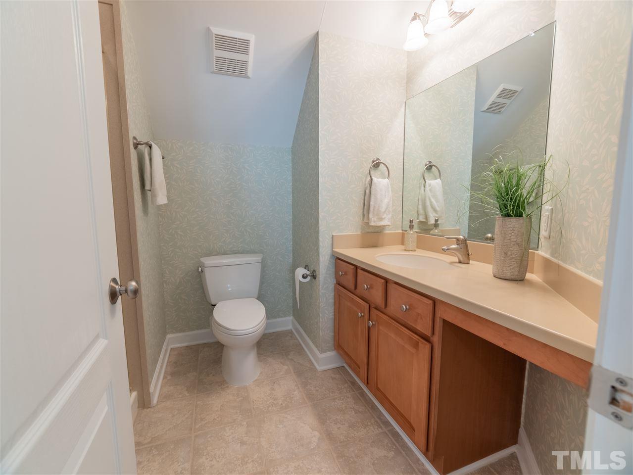 4016 White Chapel Way Raleigh, NC 27615 - Photo 25 of 30 Full bath on 3rd level features tile flooring, comfort height cabinet with Corian top and integrated sink, brushed nickel fixtures, Toto commode and full Corian walk-in shower.