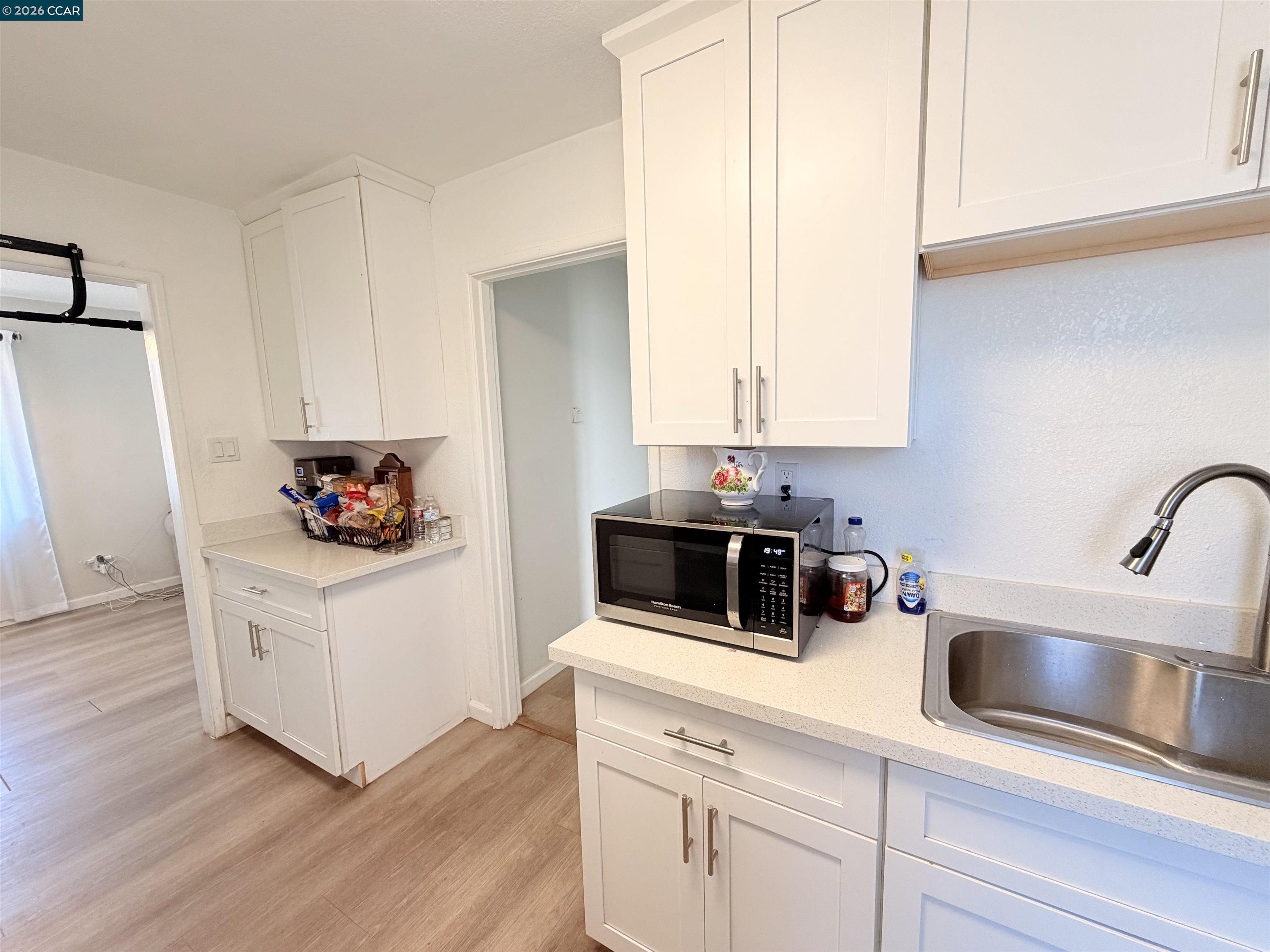 238 Fitzpatrick Road Oakland, CA 94603 - Photo 9 of 18 a kitchen with white cabinets sink and white appliances
