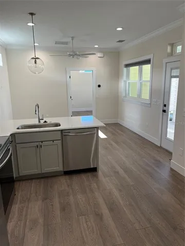 a kitchen with a sink window and wooden floor