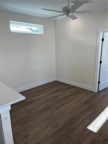 a view of a room with wooden floor and fan