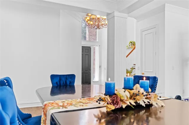 a dining room with furniture a chandelier and wooden floor