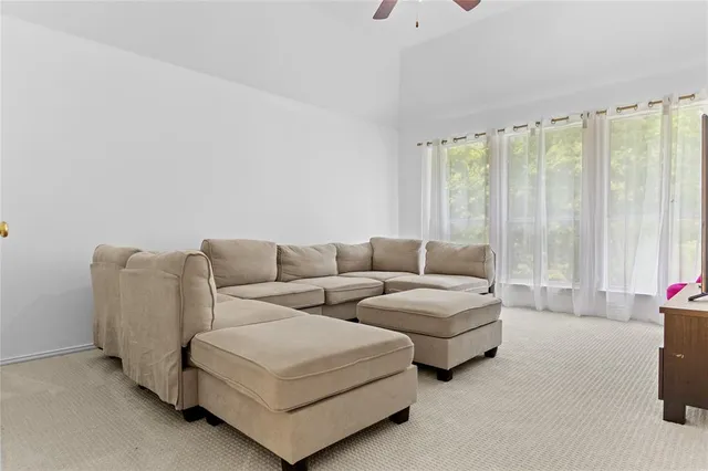 a living room with fireplace furniture and a large window