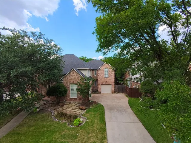 an aerial view of a house with a yard and lake view