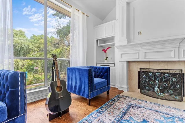 a living room with furniture a fireplace and a large window