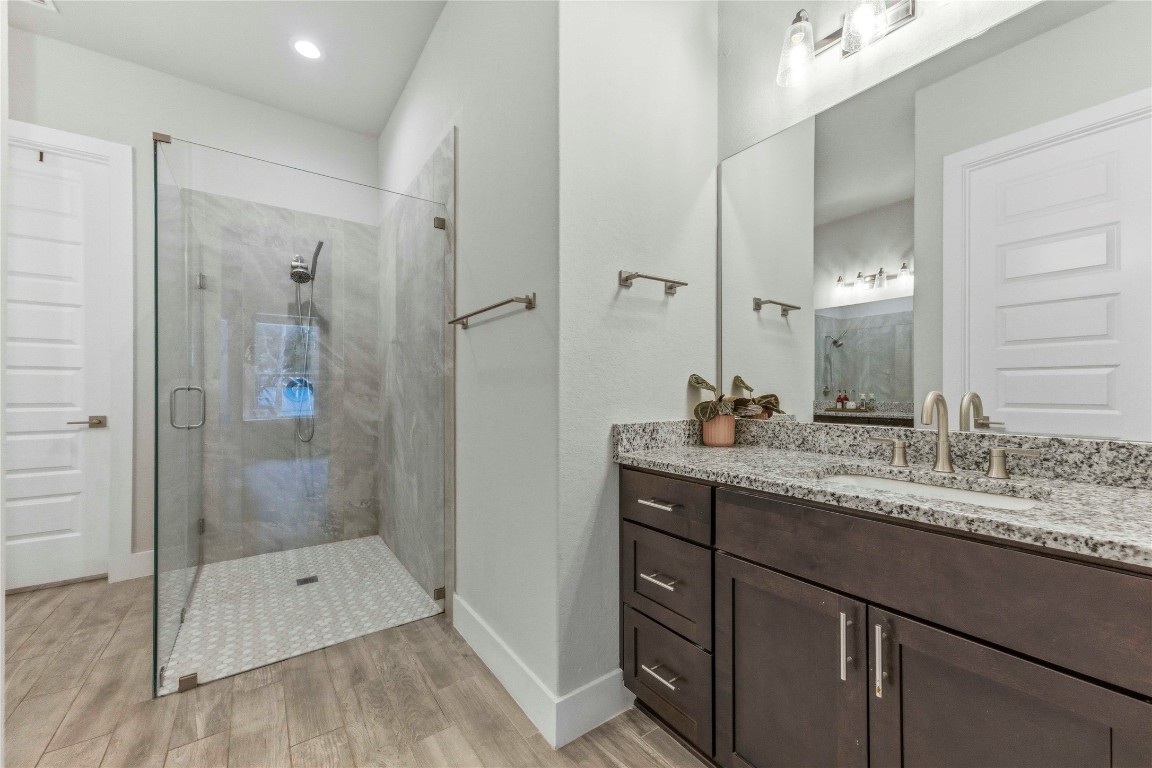 184 Granite Road Spring Branch, TX 78070 - Photo 13 of 27 Full bath with light wood-type flooring, a stall shower, vanity, and recessed lighting