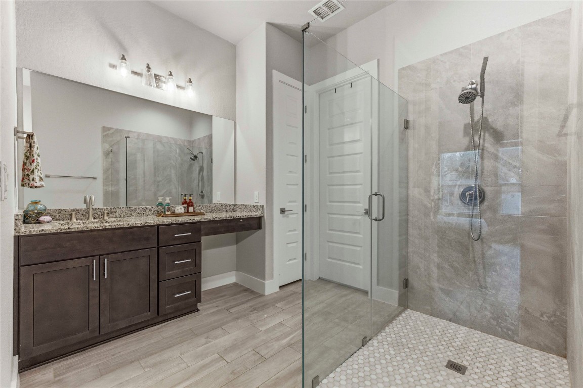 184 Granite Road Spring Branch, TX 78070 - Photo 14 of 27 Full bathroom featuring vanity, a shower stall, and wood finish floors