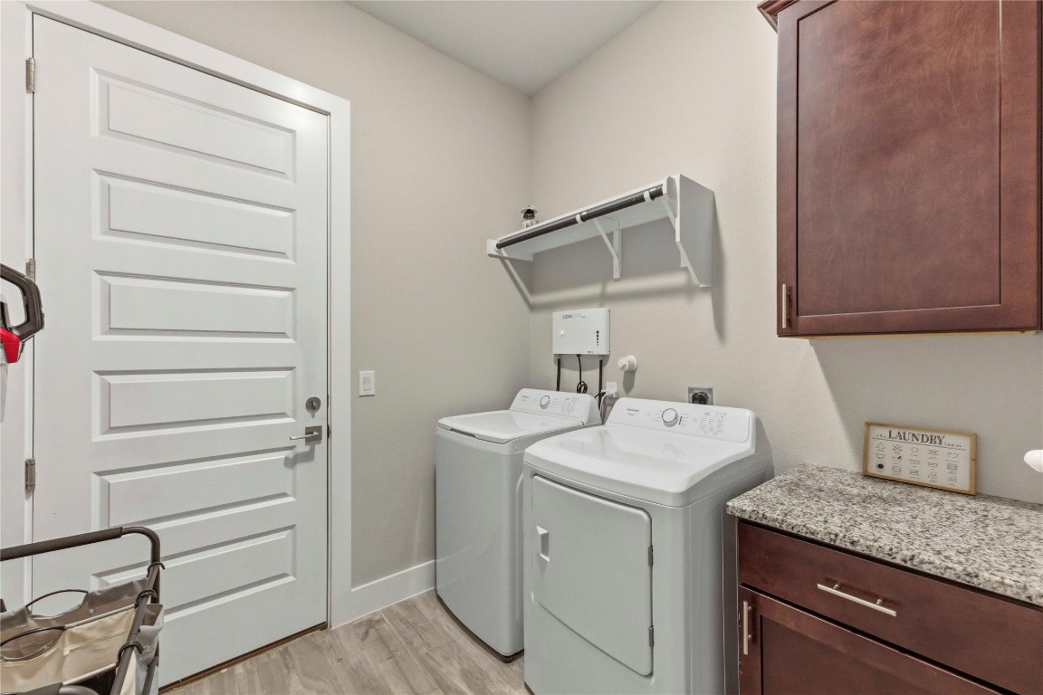 184 Granite Road Spring Branch, TX 78070 - Photo 20 of 27 Washroom with cabinet space, light wood finished floors, and washer and dryer
