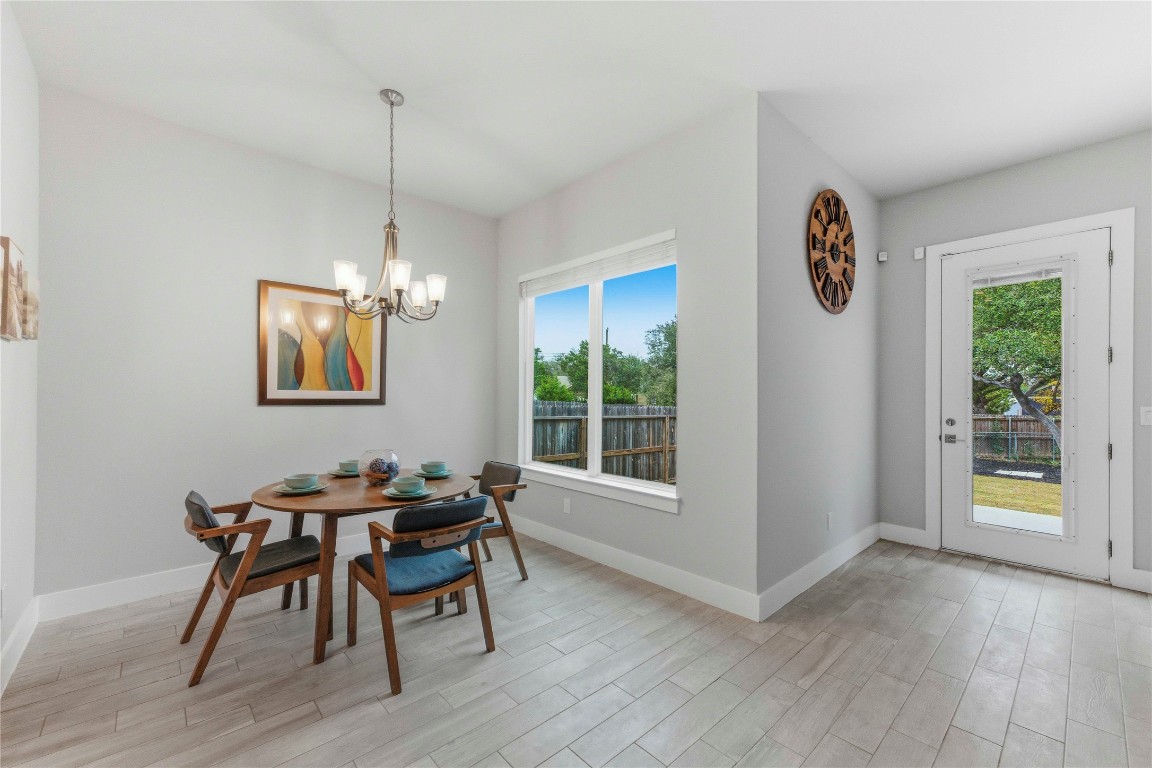 184 Granite Road Spring Branch, TX 78070 - Photo 10 of 27 Dining room featuring plenty of natural light, wood tiled floors, and a chandelier