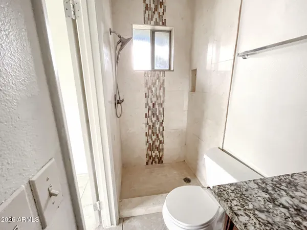 a bathroom with a toilet and a shower