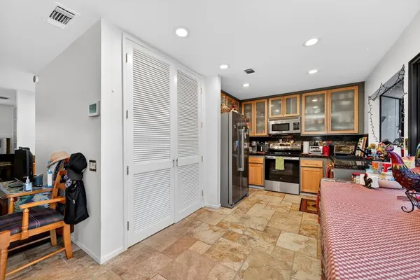 a kitchen with stainless steel appliances kitchen island granite countertop a refrigerator and a sink