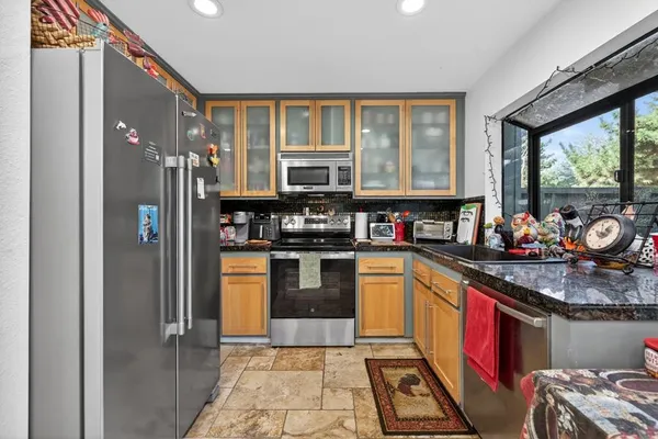 a kitchen with stainless steel appliances granite countertop a stove and a refrigerator