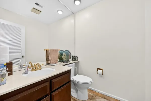 a bathroom with a granite countertop sink mirror vanity and toilet