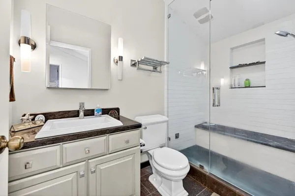 a bathroom with a sink toilet vanity and shower