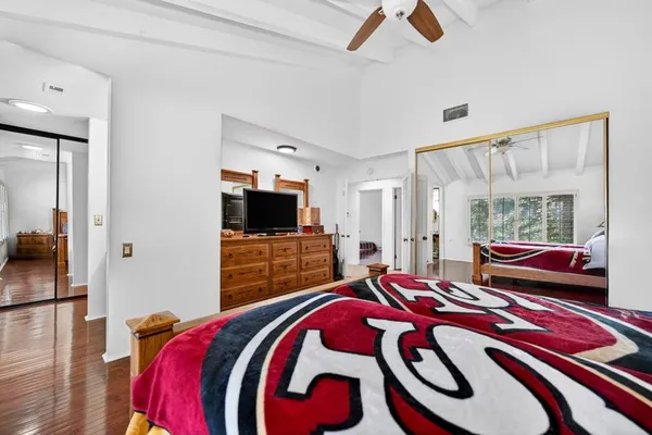 a bedroom with a bed and a flat tv screen on dresser