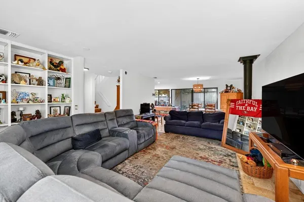 a living room with furniture a flat screen tv and a floor to ceiling window