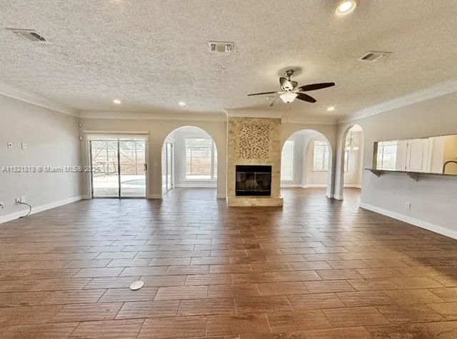 a view of empty room with wooden floor and fireplace