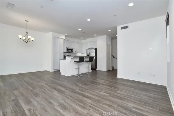 a view of a kitchen with a refrigerator and a stove top oven