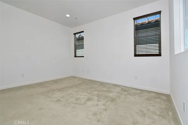 an empty room with white cabinet and mirrors