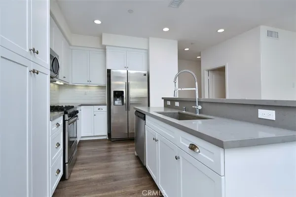 a kitchen with stainless steel appliances granite countertop a sink stove and refrigerator