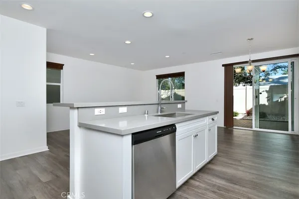 a kitchen with a sink and wooden floor