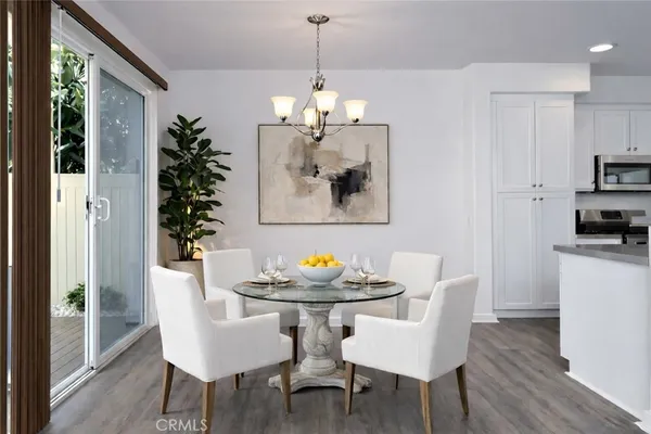 a dining room with furniture a chandelier and wooden floor